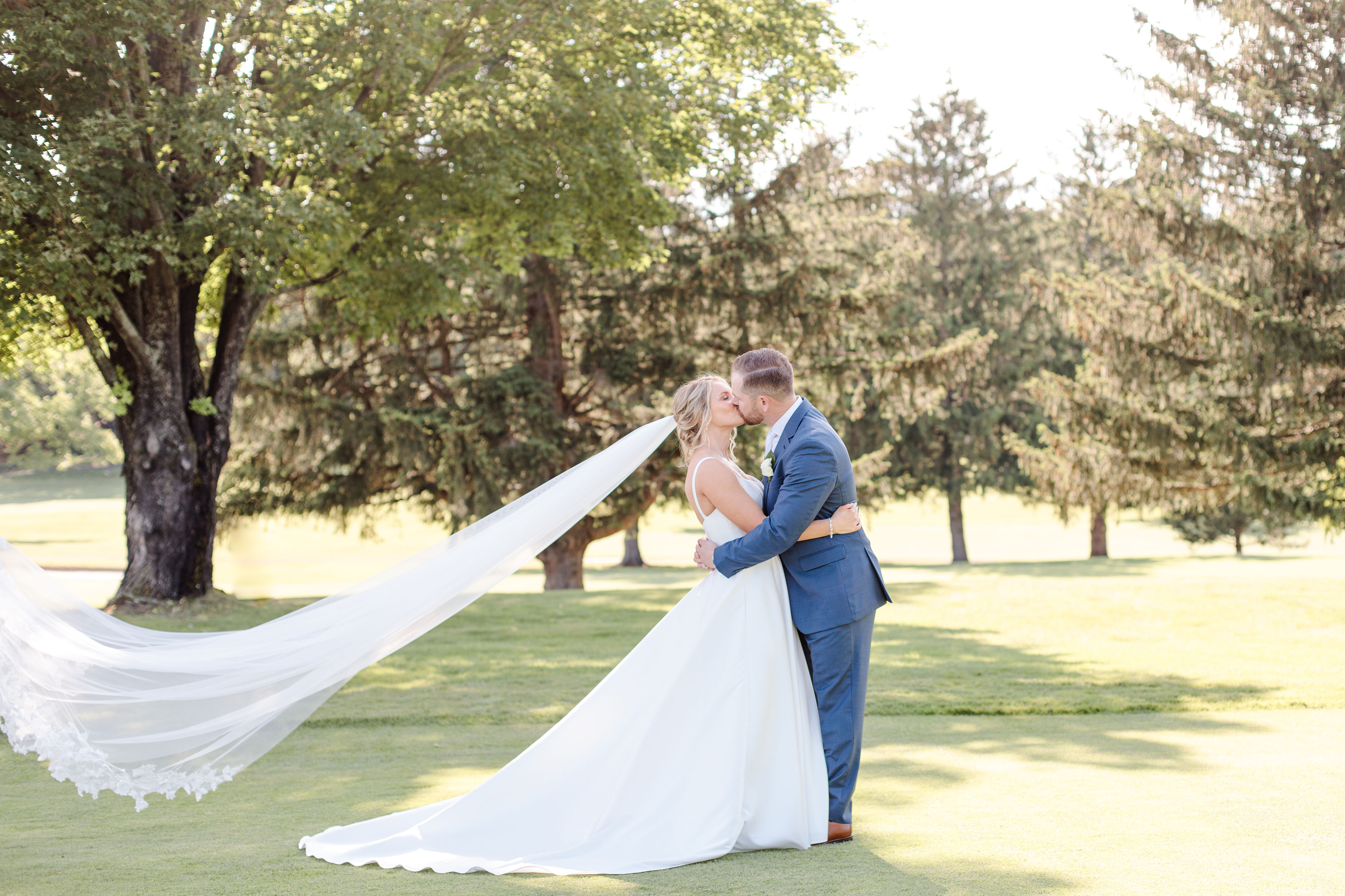 Passionate wedding kiss outdoors with serene landscape