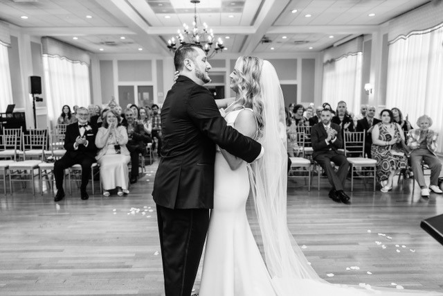 Timeless candid black-and-white portrait of bride and groom ballroom ceremony